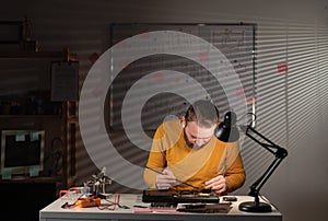 Repairman working in technical support fixing computer laptop, cleaning dirt with brush