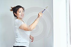 Repairs in the apartment, the girl makes repairs in the apartment, paint the walls with a roller