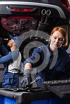 Repairwoman taking wrench while african american