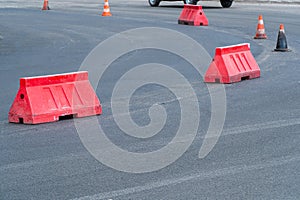 Repaving. New asphalt road. Plastic road fencing. Red barriers on the road photo