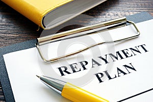 Repayment plan with clipboard and pen. photo