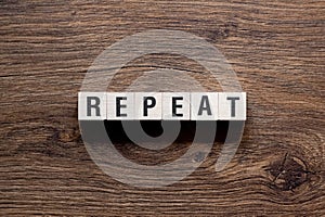 Repeat - word concept on building blocks, text