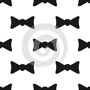 Repeated silhouette of bow tie. Simple seamless pattern.