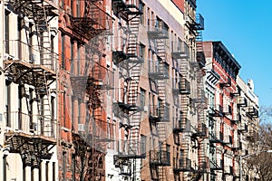 Repeating pattern of fire escapes on colorful old buildings in New York City