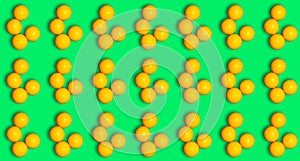 Repeating pattern with round yellow vitamins ascorbic acid on a green background. Prevention of colds
