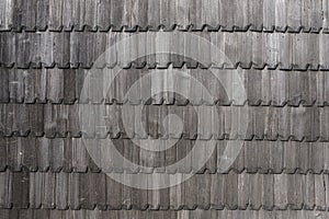 Repetition pattern of an old weathered shingle wall surface. Texture of grey wood planks background. Rustic vintage backdrop