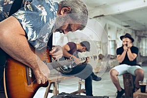 Repetition of rock music band. Electric guitar player and drummer behind the drum set.