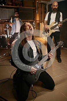 Repetition of rock music band inside home garage and expressive guitarist