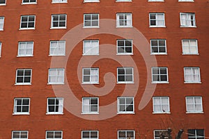 Repetitive Orange Brick Building Facade with Grid Windows Pattern