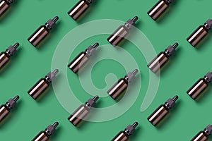 Repetitive pattern with cosmetics bottle on green background top view