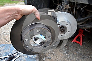 Replacement of the brake disc at the car in domestic conditions. the car repairman removes the worn brakes and puts on new ones. h