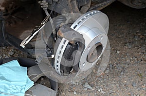 Replacement of the brake disc at the car in domestic conditions. the car repairman removes the worn brakes and puts on new ones. h