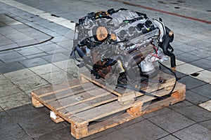Replacement engine used on a pallet mounted for installation on a car after a breakdown and repair in a car repair workshop as a