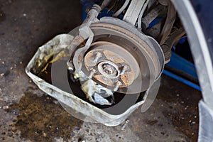 Replacement old car disc brakes, close up. Disc brake on car in process replacement new tire. Auto mechanic repairing car brake.