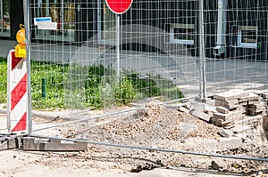 Replacement of the paving tiles or cobblestone bricks of the pedestrian sidewalk in the city with construction safety metal barrie