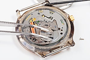 Replacing battery in quartz watch by tweezers