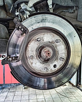 Replacing brake pads and discs in a car on a lift at a service center