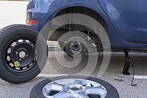 Replacing car wheels and tires concept.Jack holds the car without wheel .Car mechanic services , repair and maintenance