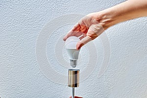 Replacing an LED light bulb in household lighting fixture for home.