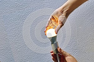 Replacing light bulb in ceiling lamp, Man uses energy saving LED lamps.