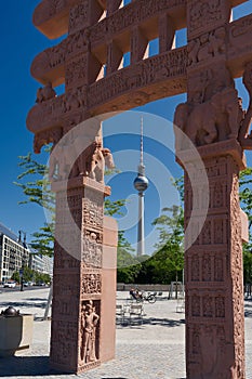 Replica of the ancient Indian Sanchi Gate made of sandstone and the television tower in Berlin