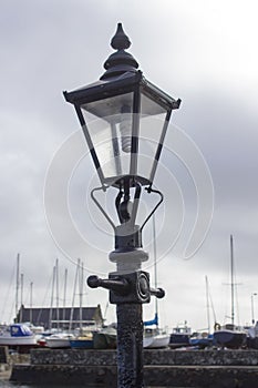 A Replica cast iron gas street lamp on the seated pavement area outside the famous Cockle Row Irish cottages at Groomsport Harbour