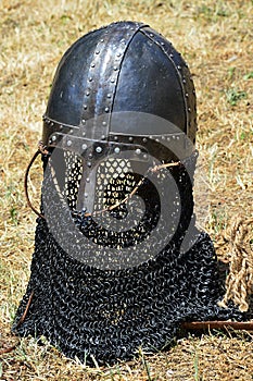Replica of conical norman casque medieval helmet with nose piece and chainmail protection of sides, mouth, neck and back.