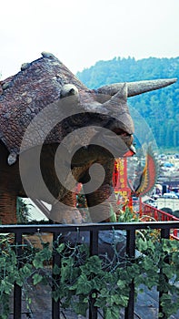 the replica dinosaur statue named triceratops at first glance looks like a rhinoceros. it has two long horns or horns on the head photo