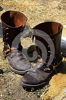 Replica of historical medieval leather splatterdashes boots with spurs displayed on medieval festival