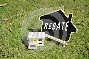 Replica house with text rebate on green grass background