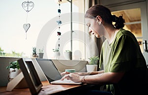 Replying customer emails. an attractive young businesswoman sitting alone in her home office and using her computer.