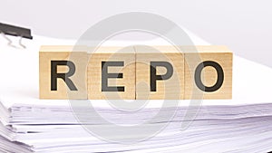 REPO written on a wooden cube with white paper background, business concept