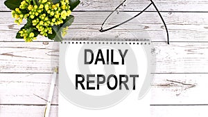 DAILY REPORT text concept write on notebook on wooden background