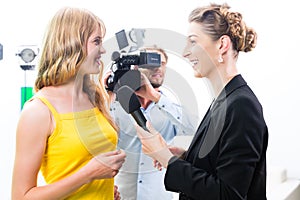 Reporter and cameraman shoot an interview