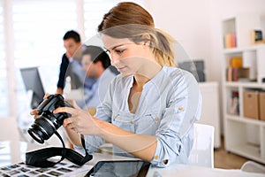 Reporter checking pictures on camera screen