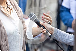 Journalist making media or vox pop interview with unrecognizable female person photo