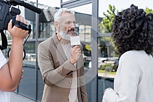 reporter with microphone interviewing african american