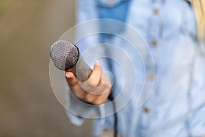 Reporter on the spot, holding microphone in hand