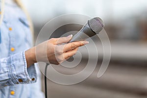 Reporter on the spot, holding microphone in hand