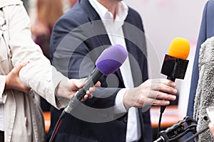 Reportes holding microphones, conducting media interview