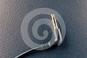 A representation of the audio technology and art, a golden plated 3.5mm jack on a black background symbolizes the