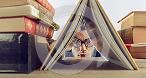 Reprimanded student hidden between the school books photo