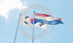 Republic of Korea and Netherlands, two flags waving against blue sky