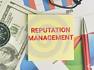 REPUTATION MANAGEMENT written on note book with pen,eye glasses,compass,money and chart.