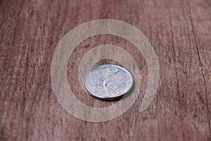 REPVBBLICA ITALIANA, Coin of Italy in reverse of a coin on the wooden floor. photo