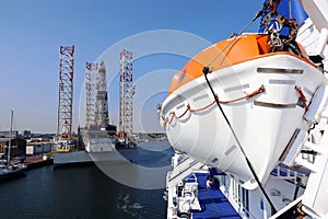 Rescue boat on a ship and an oil rig in the sea