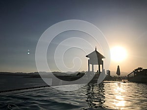 Rescue booth, tower, rescue post on the edge of the water of a luxurious infinity pool merging with the horizon against the backdr