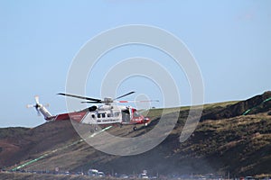 Rescue helicopter in clear blue sky and land