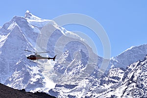 Rescue helicopter in flight over snow capped