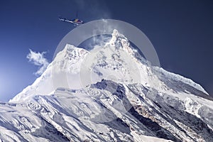 Rescue helicopter over snowy mountain peak